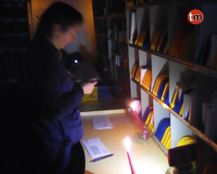 Operarios de Correos de O Val Miñor trabajan con velas al cortar la empresa proveedora el suministro eléctrico