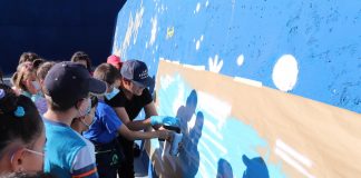 Alumnos de A Guarda colaboran en el pintado del espigón del puerto