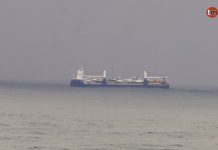 Un buque cargado con yates cruza la costa de Oia